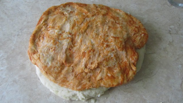 sverhu lepeshka iz testa s paprikoj